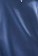 Woman wearing a blue satin nightgown sitting on a brown leather chair.